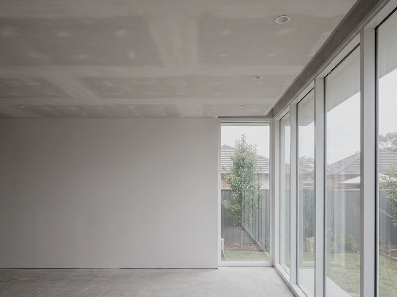 Panelled plasterboard ceiling with recessed downlights above full height glazing