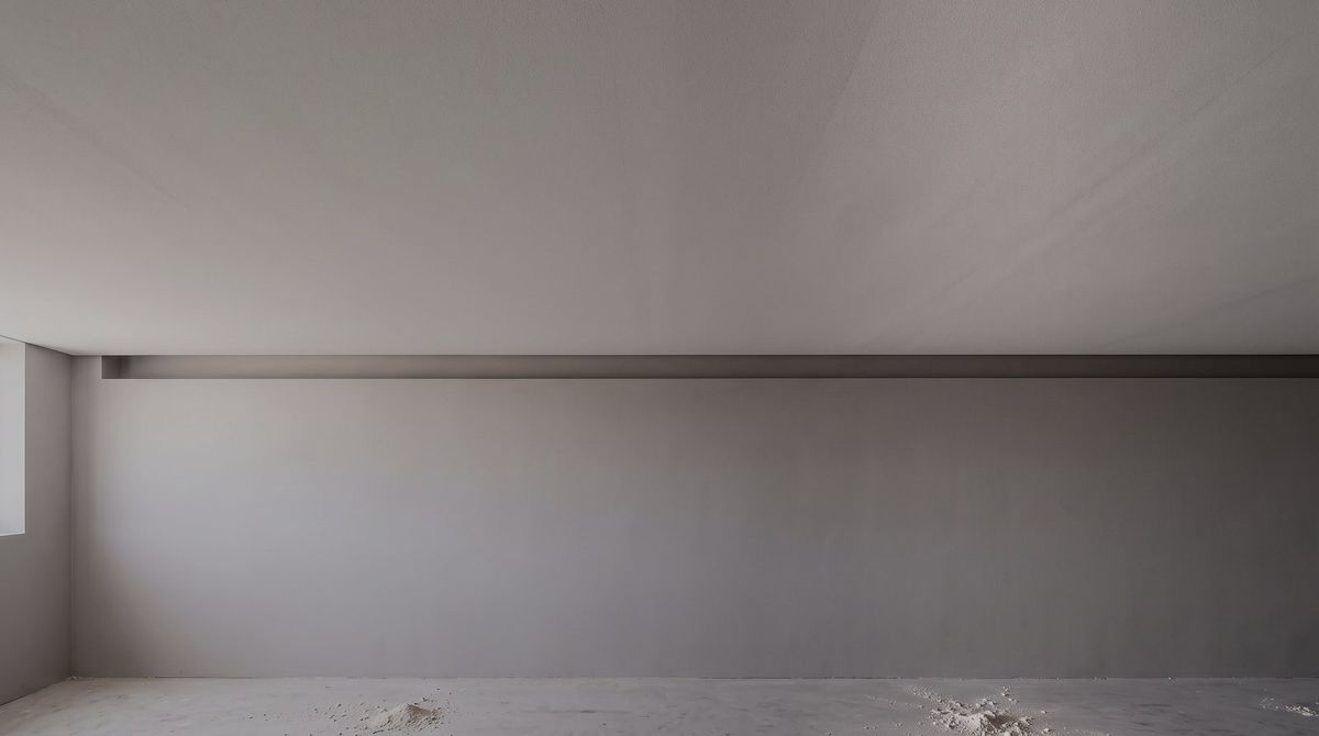 Recessed shadow line detail where a plasterboard ceiling meets the wall, picked out by low raking light