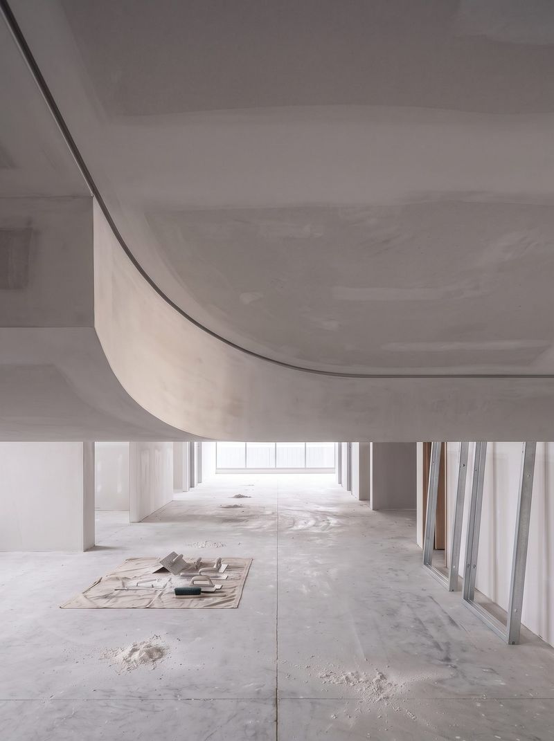 Curved plasterboard bulkhead ceiling with a recessed shadow line along its edge