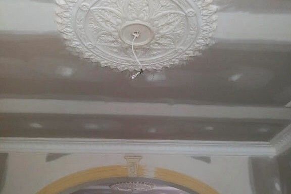 Ornate plaster ceiling rose and decorative cornice in a restored period room