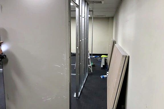Office corridor fitout with plasterboard walls sheeted and set ready for paint